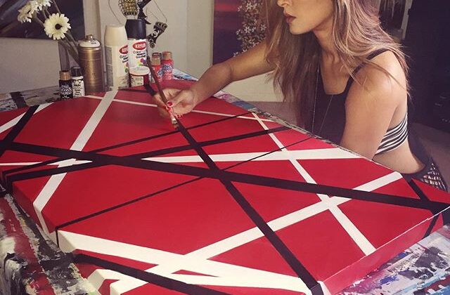 A woman painting at Van Halen's iconic guitar stripes