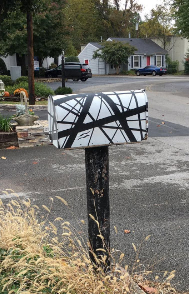 Mailbox painted with black-and-white Eddie Van Halen guitar stripes